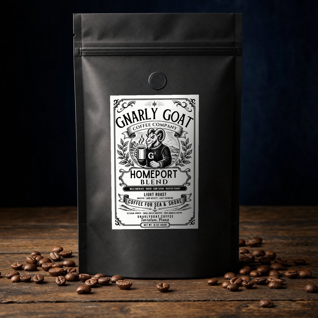 Gnarly Goat Homeport Blend, a matte black 16 ounce coffee bag with the engraved heritage label, photographed on a weathered wood surface with roasted beans scattered around it